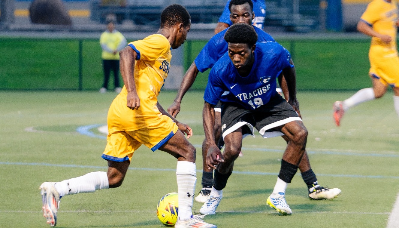 SUNY POLY men's soccer player cuts through opposing defense