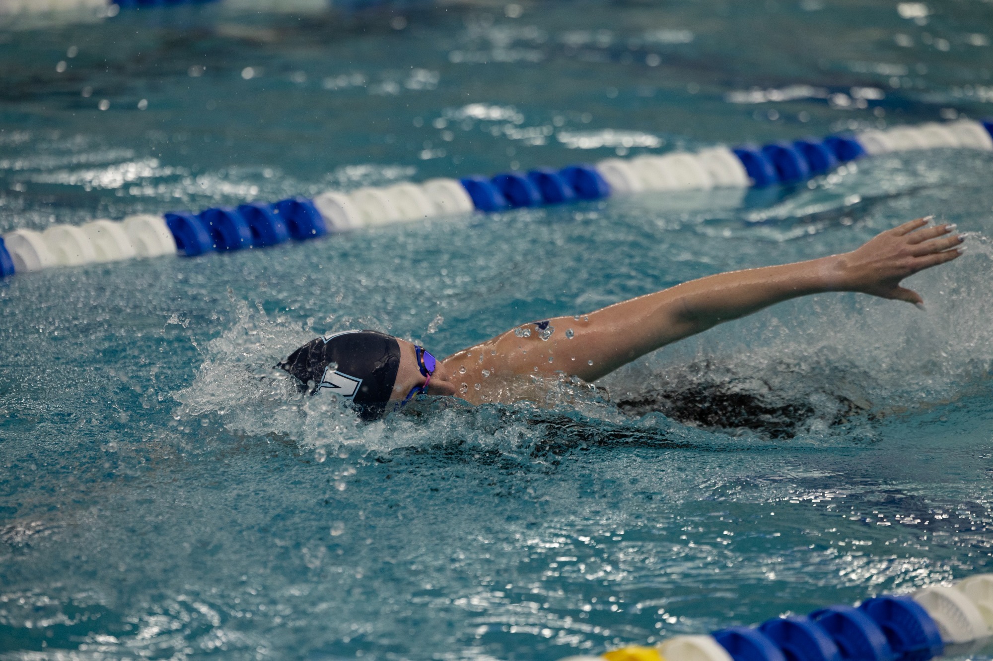 A UMW women's swimmer is swimming in the freestyle event