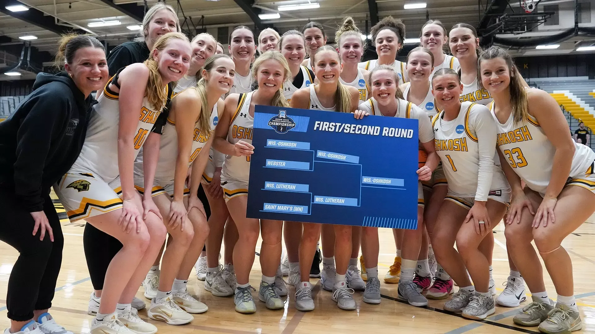 2026 Women's Basketball Team Photo, Holding the regional bracket after defeating Wisconsin Lutheran