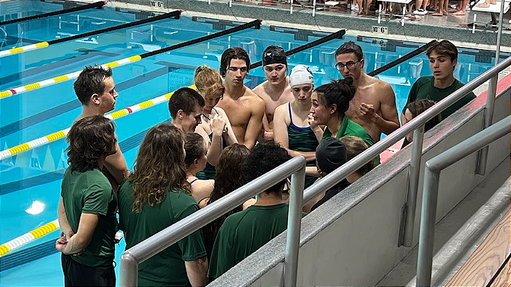 The 2022-2023 Warren Wilson Team gather around coach Rebecca Westfall at swim meet vs Mars Hill