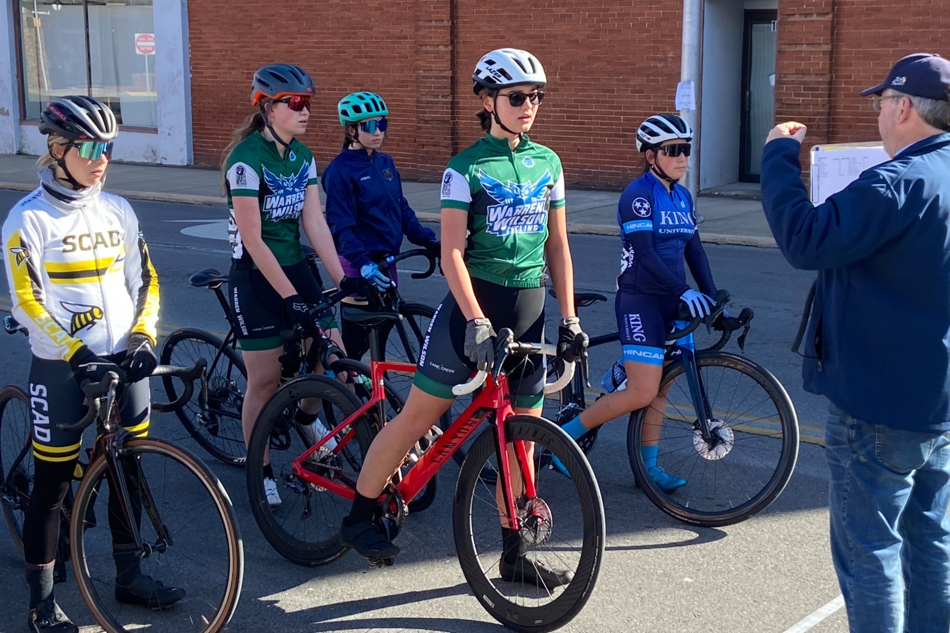 Several Warren Wilson riders talk to the starting official before the cycling rice begins.