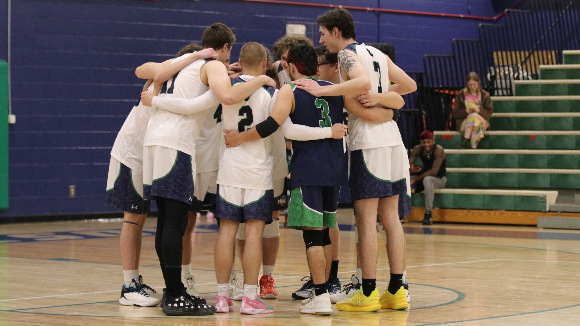The 2024 Men's Volleyball team huddles together after the game