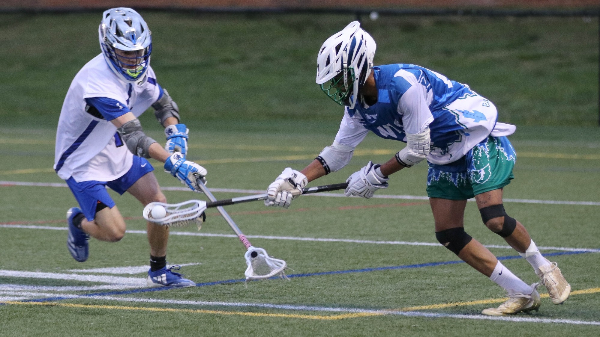 2024 Men's Lacrosse player, Max Charles grabs the ball in his stick during the faceoff.