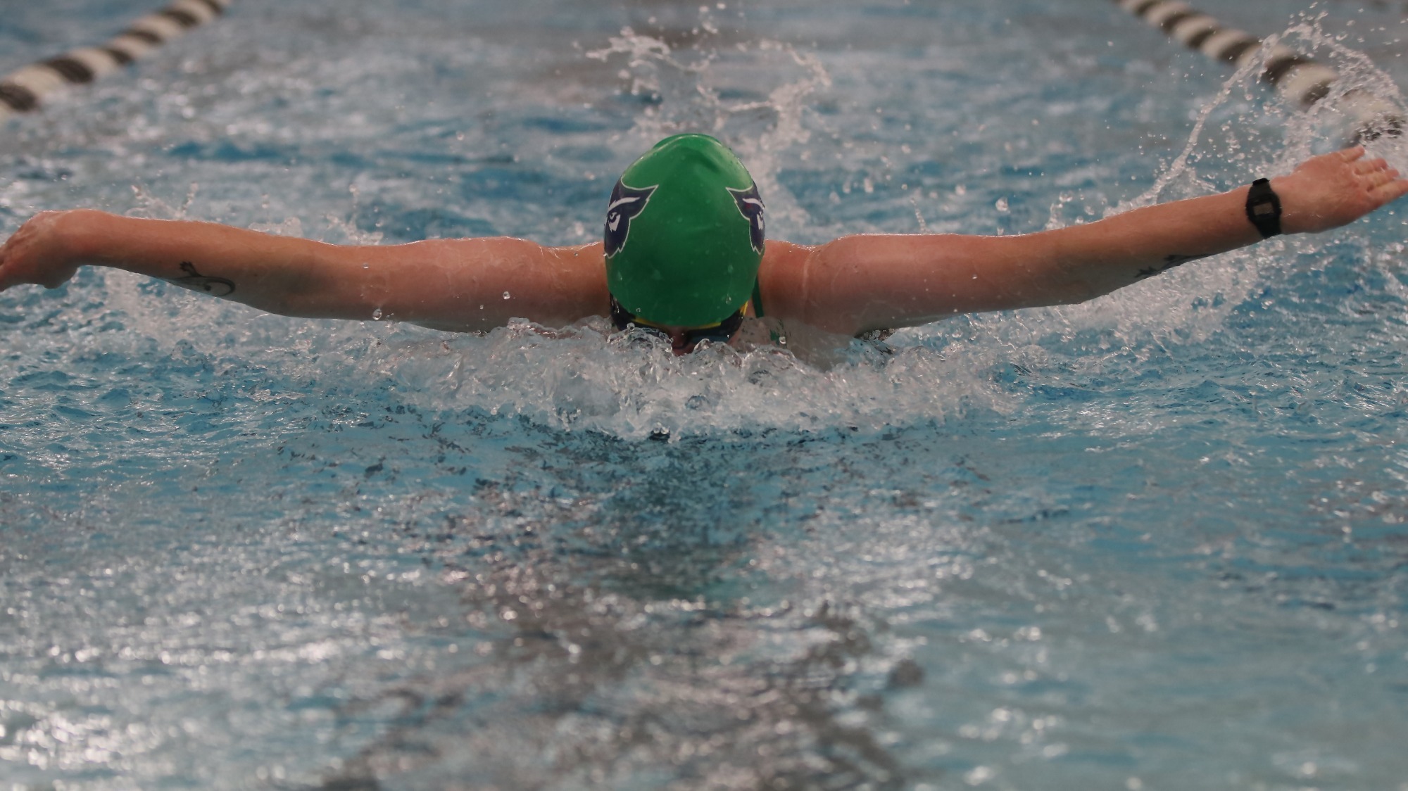 2024 Warren Wilson Swimmer swims butterfly with arms outstretched in pool.