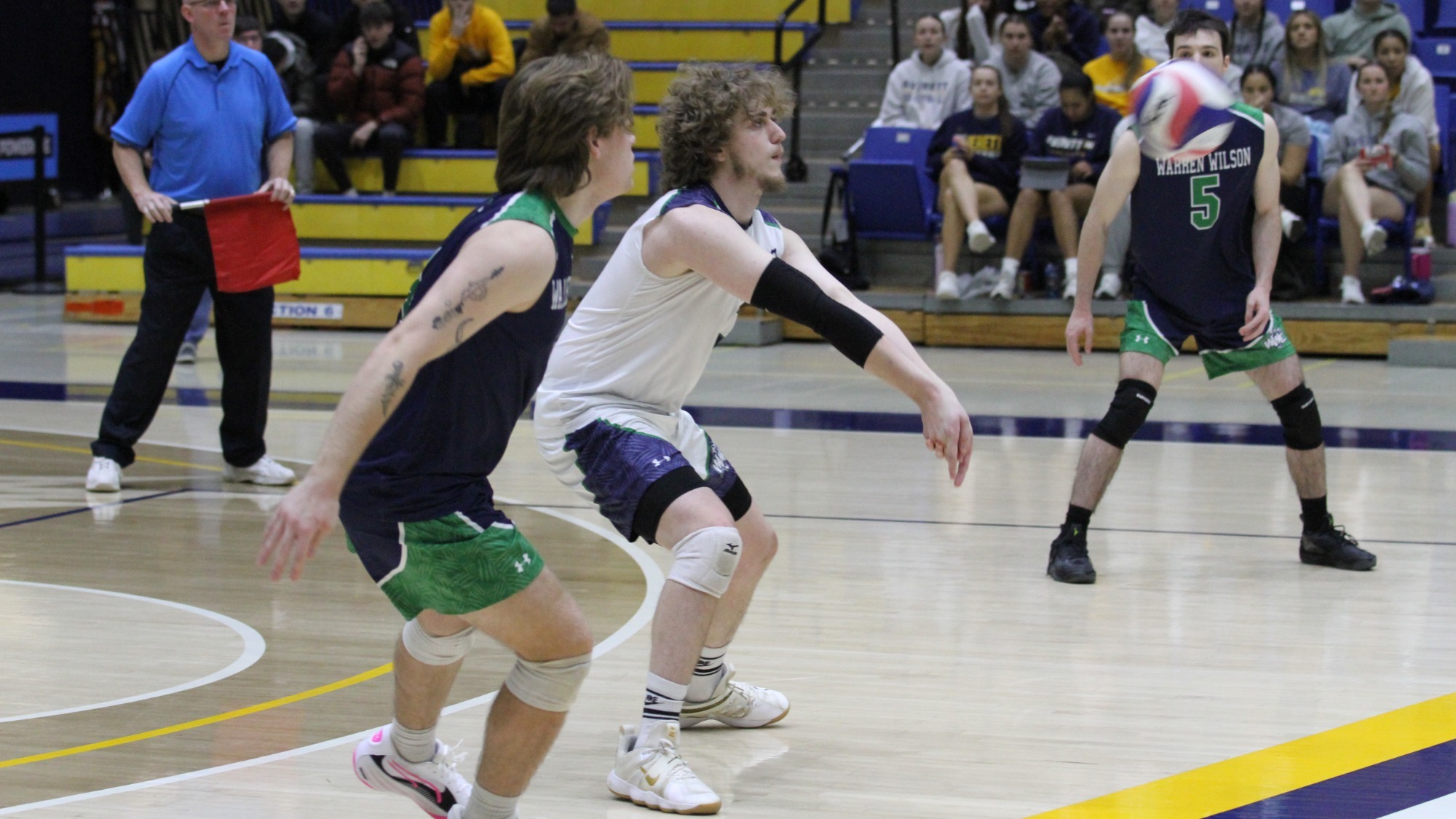 24-25 Men's volleyball player bumps the ball from the opposing team's serve.