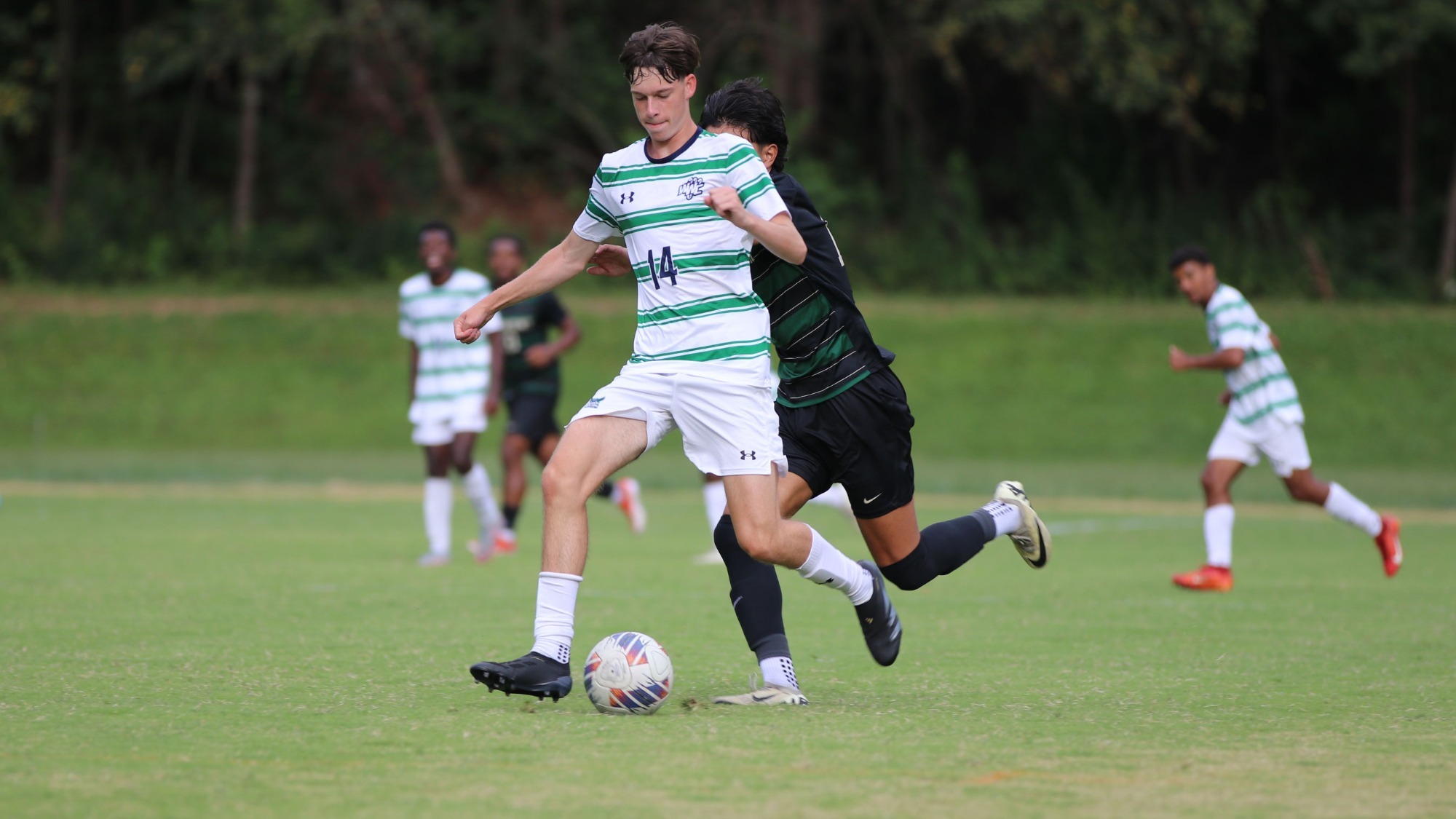 Warren Wilson Men's Soccer player, William Tobin dribbles the ball past his opponent.