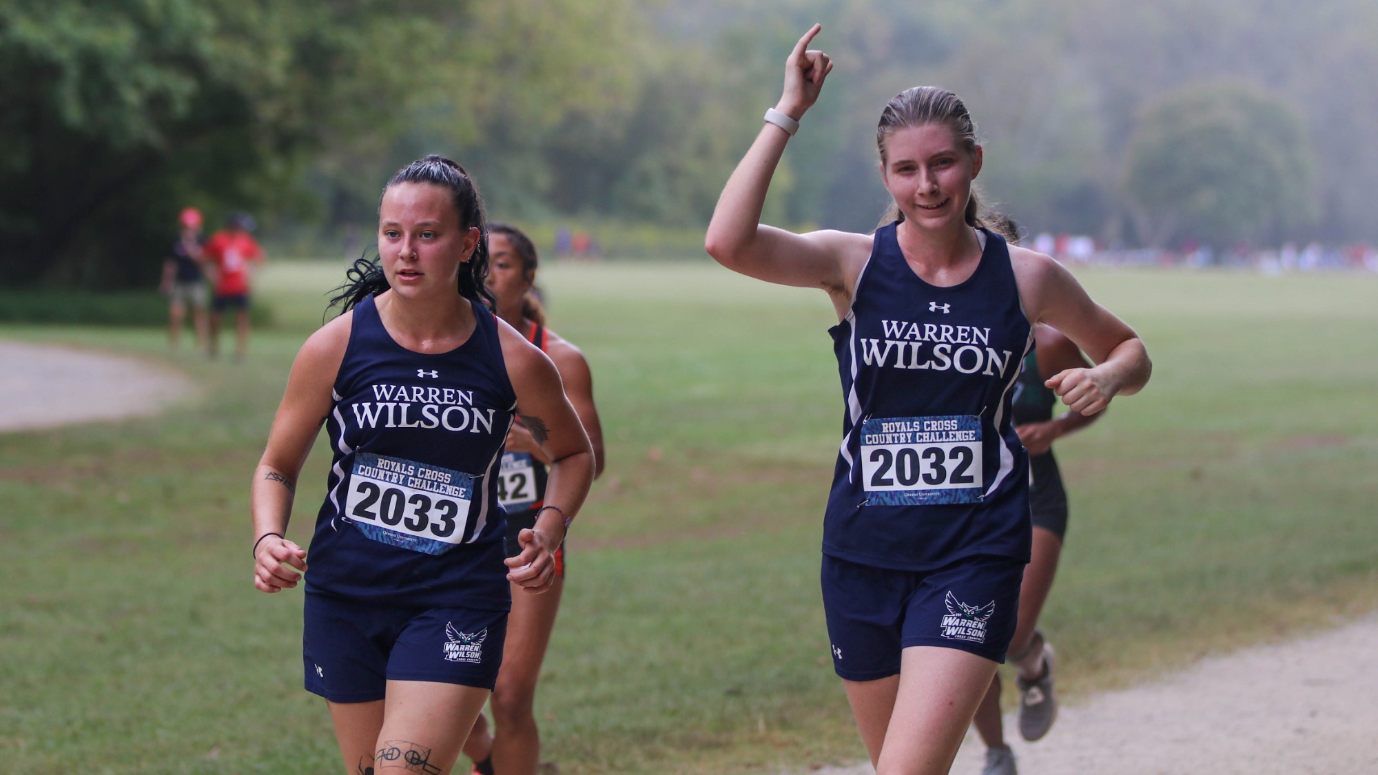 Two runners from the Warren Wilson College cross country team says hello as they run by